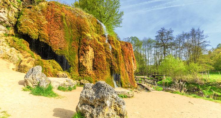 Moosbewachsene Felsformation mit einem kleinen Wasserfall.