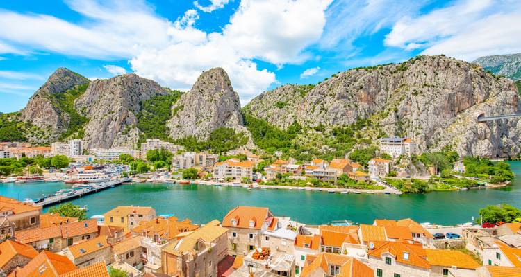 El vibrante pueblo ribereño de Omiš enmarcado por acantilados de piedra caliza imponentes y tejados de terracota.
