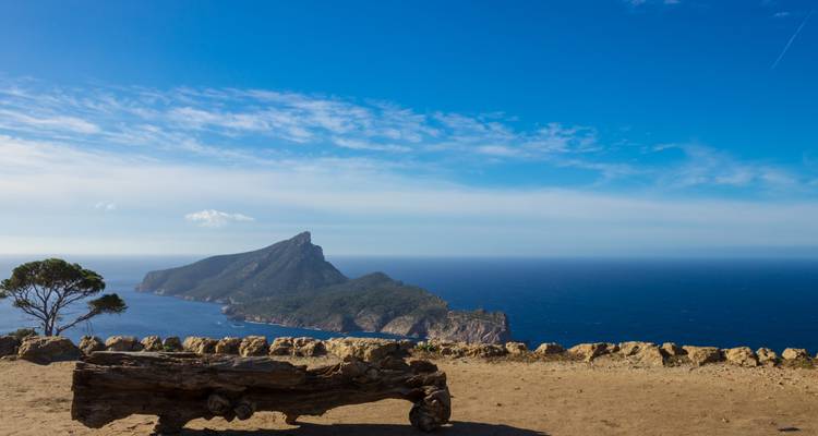 Paysage montagneux avec vue sur l'océan et ciel dégagé.