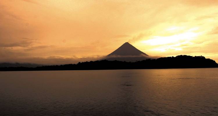 Volcano silhouette against a colorful sunset sky.