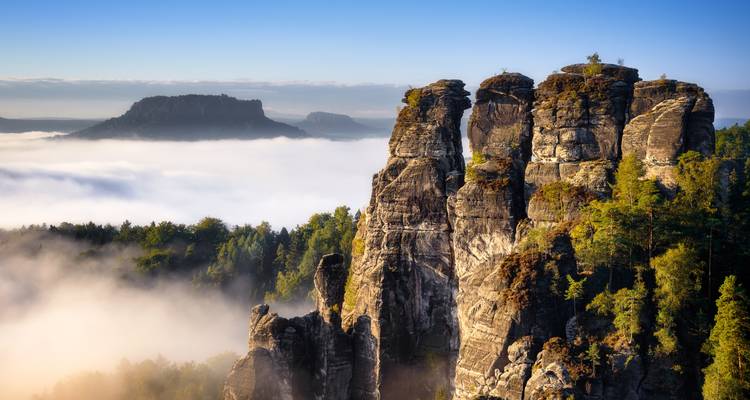 Epische Aussicht auf Klippen, die sich über ein Nebelmeer erheben.