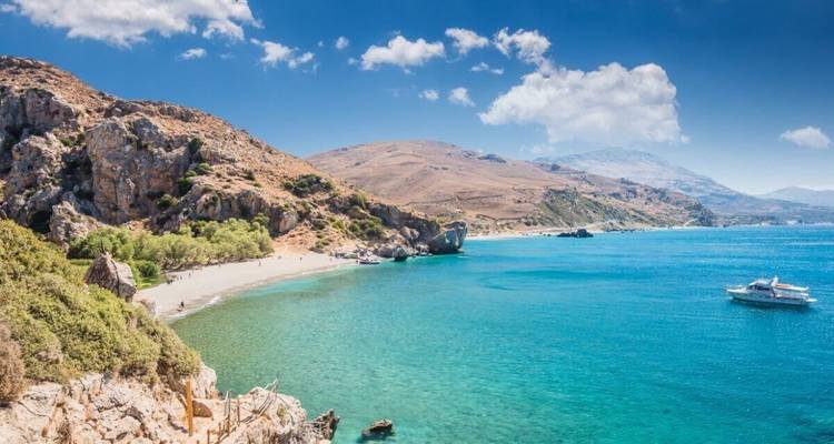 Prachtig strand met helder turquoise water en een kleine boot.