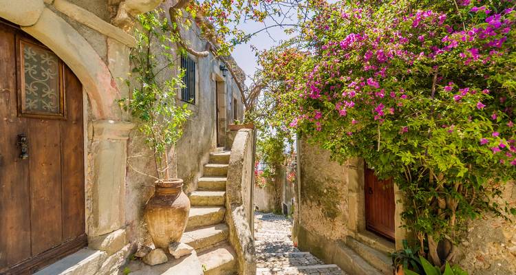 Charmante Steingasse mit Treppen und leuchtend blühende Bougainvillea in voller Blüte