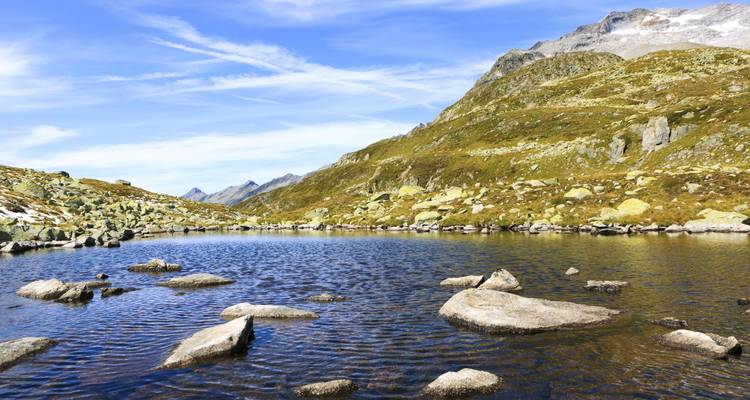See umgeben von felsigem Gelände und Bergen.