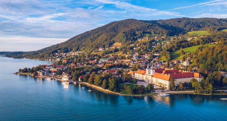 Luftaufnahme einer Seestadt und der umliegenden Hügel.