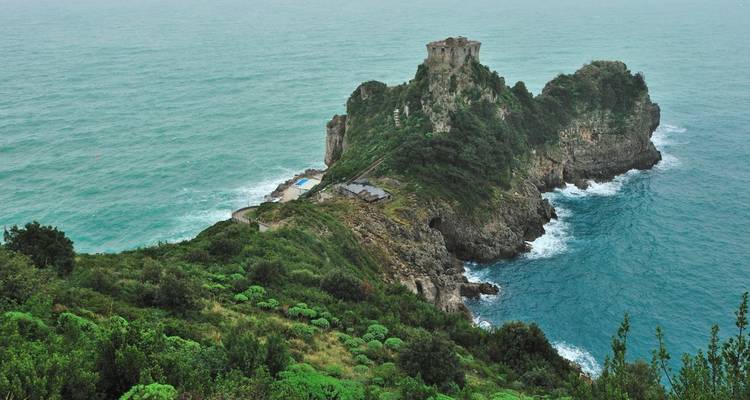 Felsvorsprung, der sich in ein türkisfarbenes Meer erstreckt.