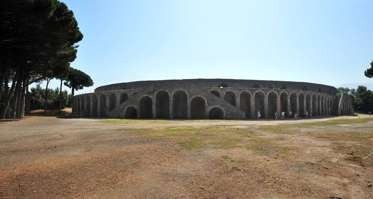 Große kreisförmige antike Struktur, umgeben von Bäumen.