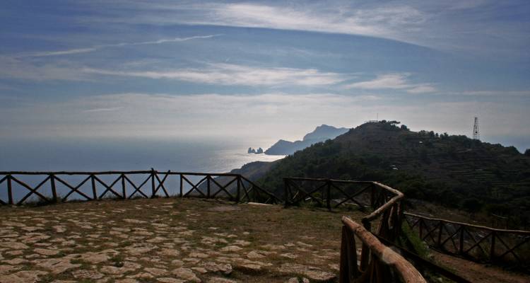 Ein Zaun mit Blick auf eine Küstenlandschaft mit dramatischem Himmel.