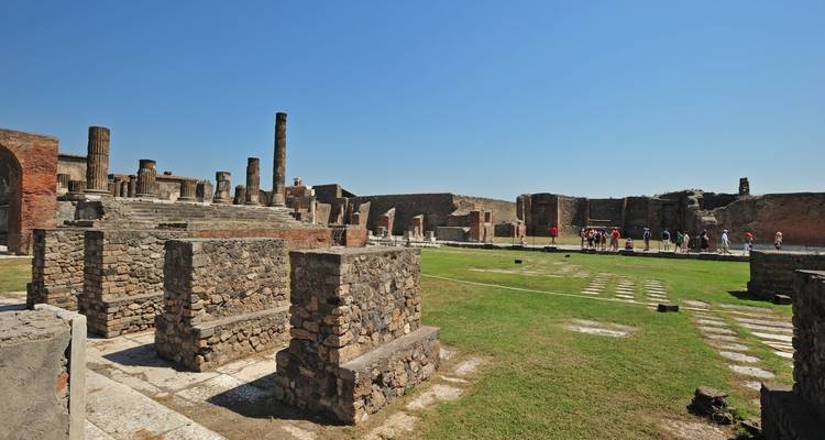 Antike Ruinen mit Touristen, die die Stätte erkunden.