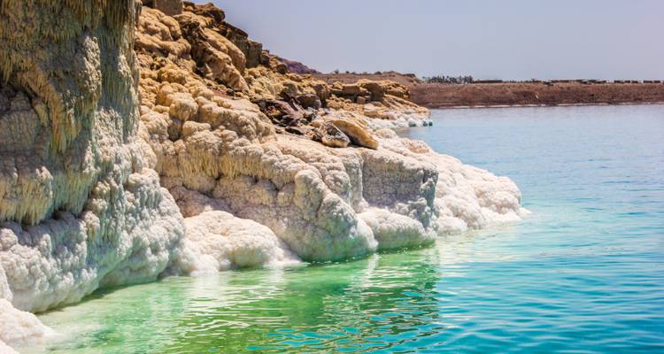 View of the Dead Sea with salt-encrusted rocks.