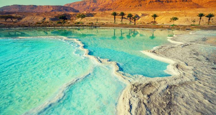 Vibrant blue water contrasting with desert landscapes.