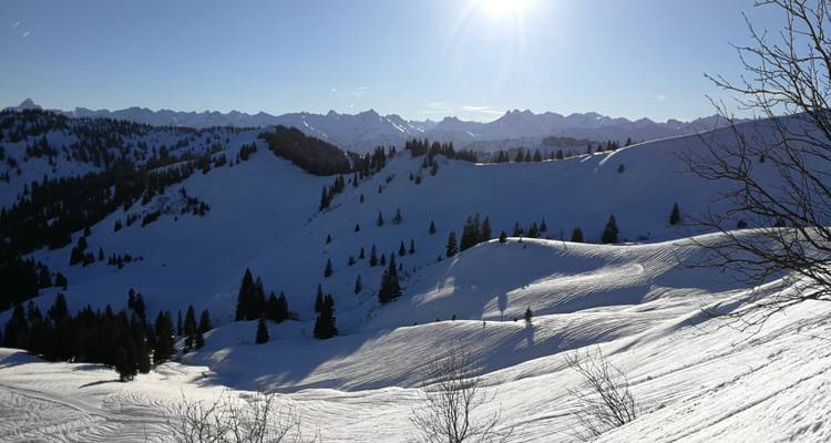 A vast snowy landscape with mountain ranges in the background.