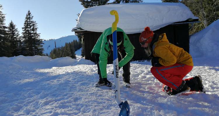 Two people interacting with some equipment in a snowy setting.