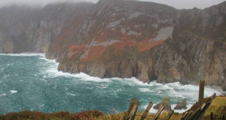 Littoral montagneux avec des vagues qui s'écrasent contre les falaises.