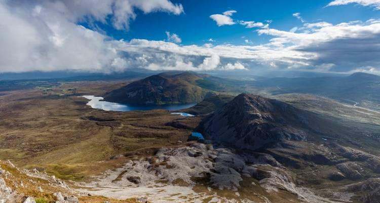 Vue aérienne de montagnes et de lacs sous un ciel bleu.