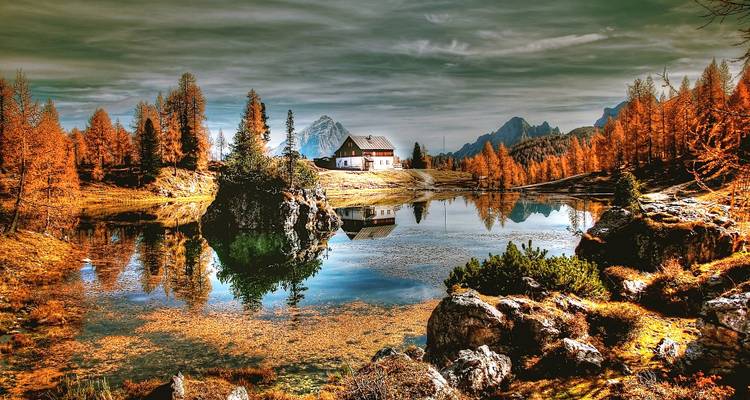 Autumn landscape with a lake and a small house.