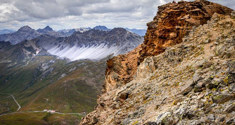 Formaciones rocosas dramáticas que dominan un valle con montañas distantes.