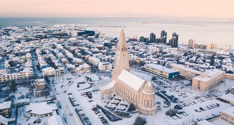 Luftaufnahme von Reykjavik im Winter mit Blick auf die markante Hallgrimskirkja-Kirche und den umliegenden Hafen.