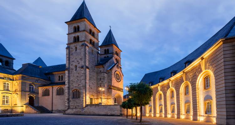 Architektonische Ansicht des beleuchteten Kirchplatzes in der Abenddämmerung.