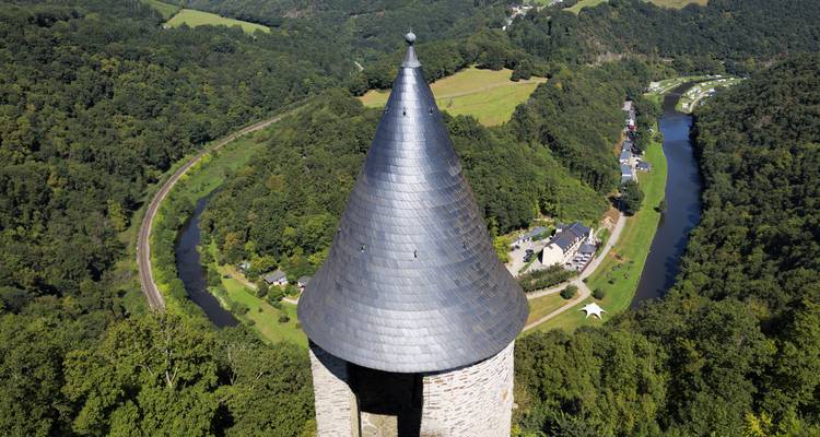 Luftaufnahme eines Turms inmitten einer üppigen Tallandschaft.