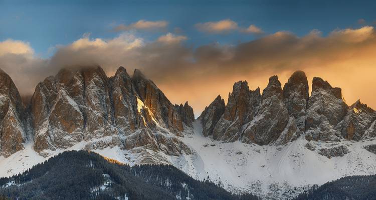Cordillera montañosa con iluminación dramática bajo un cielo del atardecer.