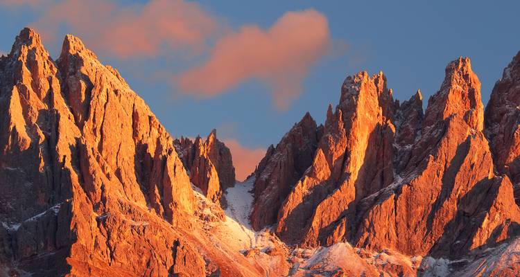 Des pics rocheux rougeoyant d'orange dans la lumière du soleil couchant.