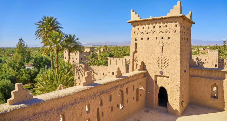 Traditionelle marokkanische Kasbah mit umgebenden Palmen.