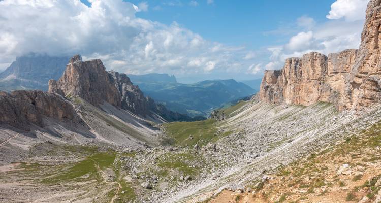 Mountain pass with dramatic peaks and a cloudy sky.