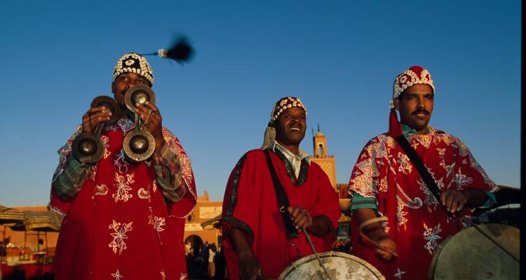 Músicos en atuendo tradicional actuando al aire libre.