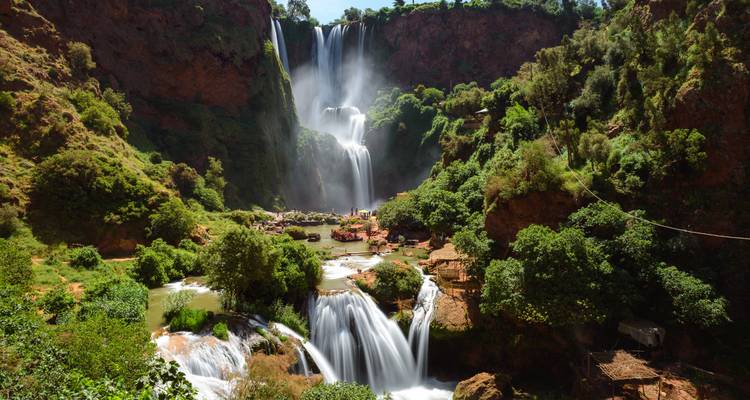 Majestuosa cascada que desciende por múltiples niveles rodeada de exuberante vegetación.