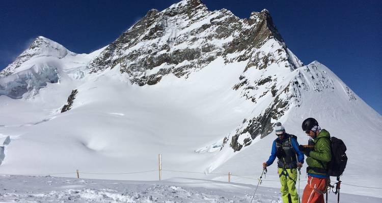 Deux skieurs sur le flanc d'une montagne enneigée.