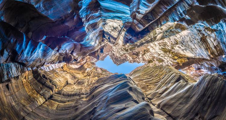 Canyon view looking up at layered rock formations.