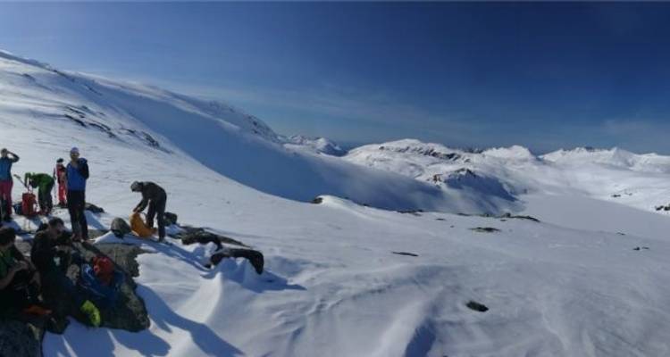 Groupe de personnes se reposant sur des montagnes enneigées, préparant leur équipement.