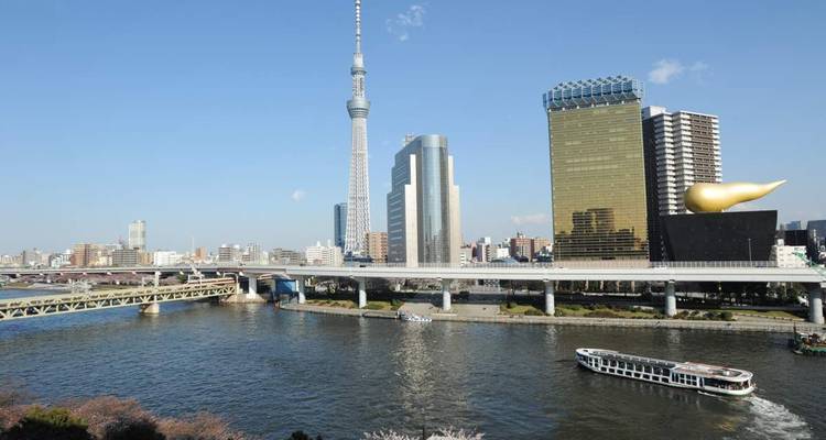 Tokio-Skyline mit Wolkenkratzern und Fluss im Vordergrund.