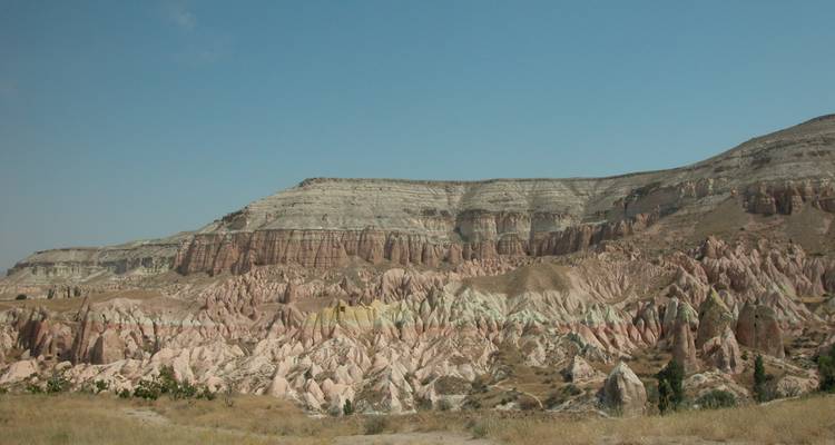 Expansive view of rock formations in Cappadocia, under a clear sky.