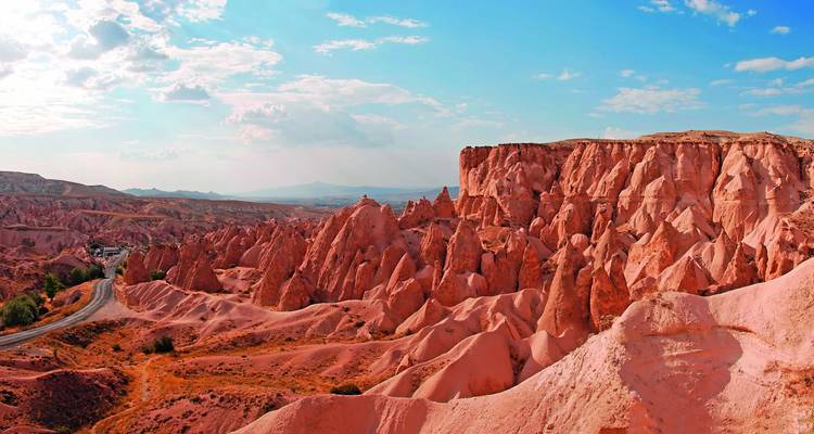 Stunning view of Cappadocia's red rock formations under a bright blue sky.
