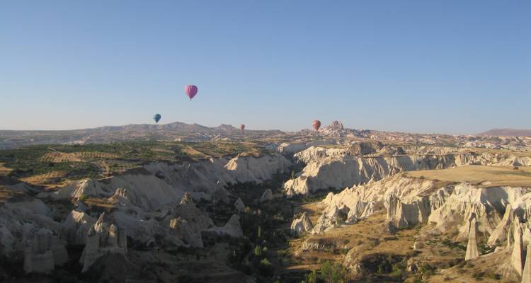Hot air balloons floating over the rock valleys of Cappadocia.