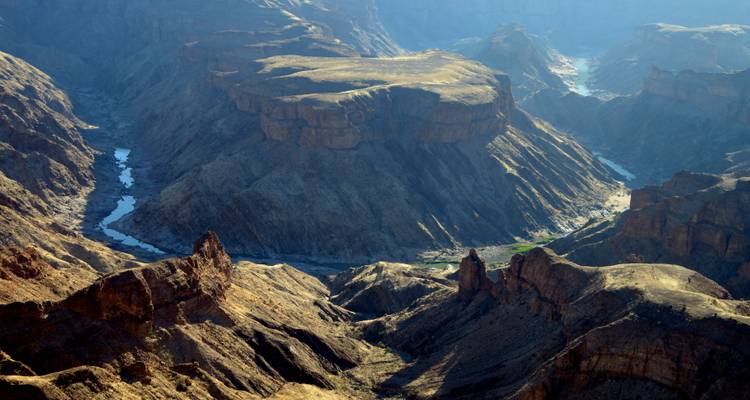 Luftaufnahme einer dramatischen Canyonlandschaft mit Fluss.