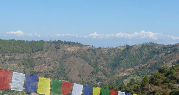Heuvels met terraslandbouw en gebedsvlaggen op de voorgrond.