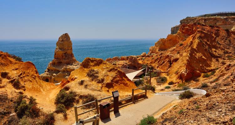 Acantilados de un naranja dramático y una alta formación rocosa con vista al profundo Atlántico azul