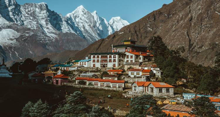 Dorp genesteld aan de voet van besneeuwde bergen.