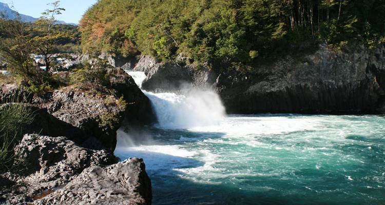 Cascade vibrante entourée de rochers et de verdure.