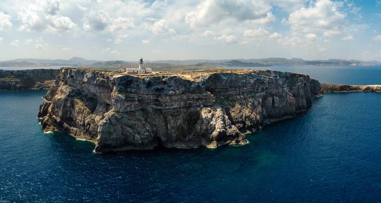 Un phare sur une falaise rocheuse au-dessus de la mer.