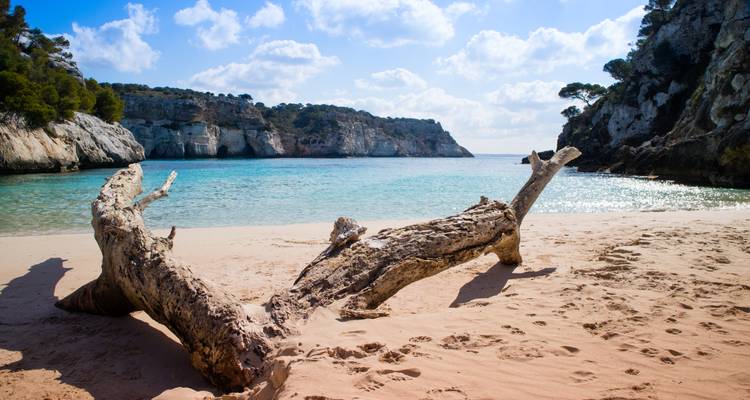 Une plage tranquille avec des eaux claires et des falaises environnantes.