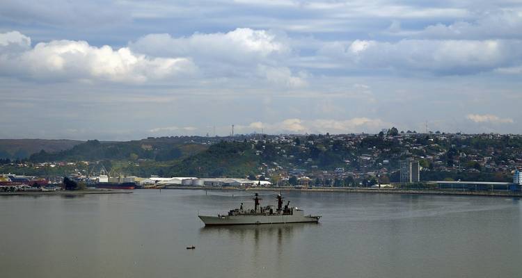 Haven met een groot schip en bewolkte lucht erboven.