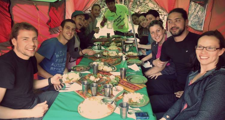 Repas de groupe à l'intérieur d'une tente avec un repas disposé sur la table.