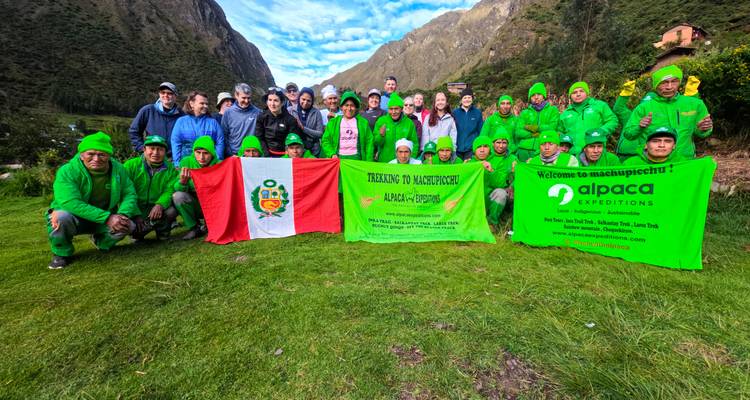 Grand groupe de randonneurs célébrant avec des bannières d'Alpaca Expedition.