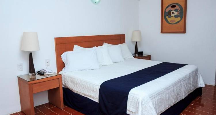 Hotelzimmer mit einem Bett und minimalistischer Einrichtung.