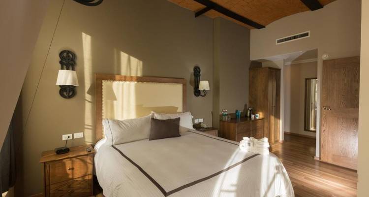 Gemütliches Hotelzimmer mit Holzmöbeln und Sonnenlicht.