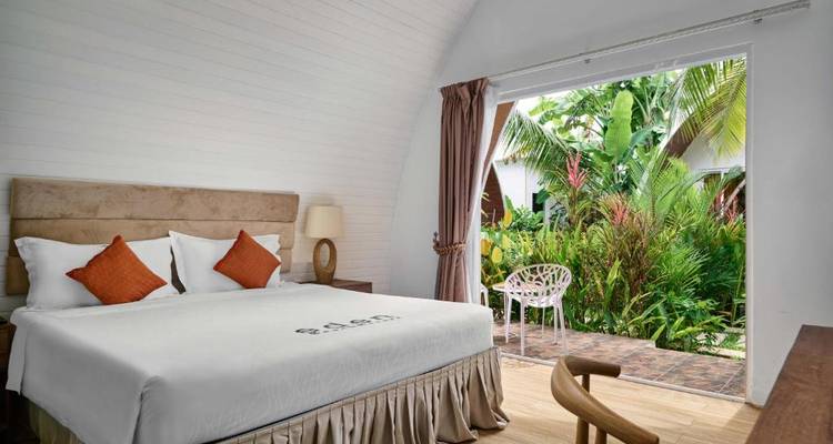 Hotelkamer met vrij uitzicht op een tropische tuin buiten.